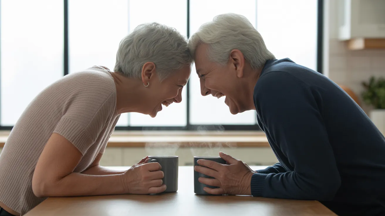 A senior couple seen from the side, laughing together over coffee at a modern kitchen table, their bodies forming a gentle curve.