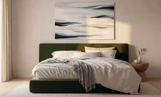 A wide view of a minimalist bedroom with a green velvet headboard and linen bedding, illuminated by soft morning light.