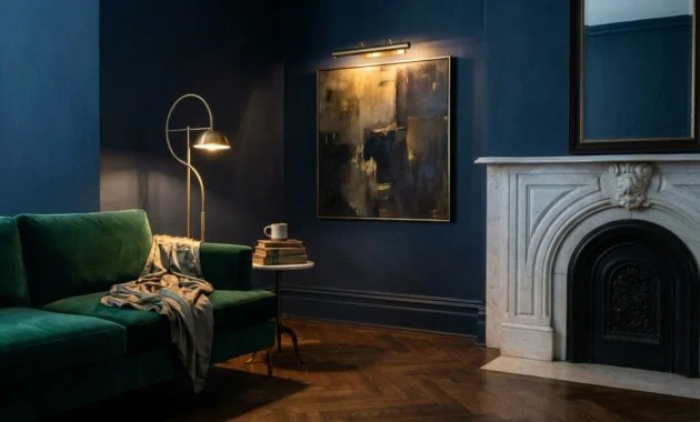 A luxurious living room in an older home featuring navy walls, a marble fireplace, and elegant layered lighting.
