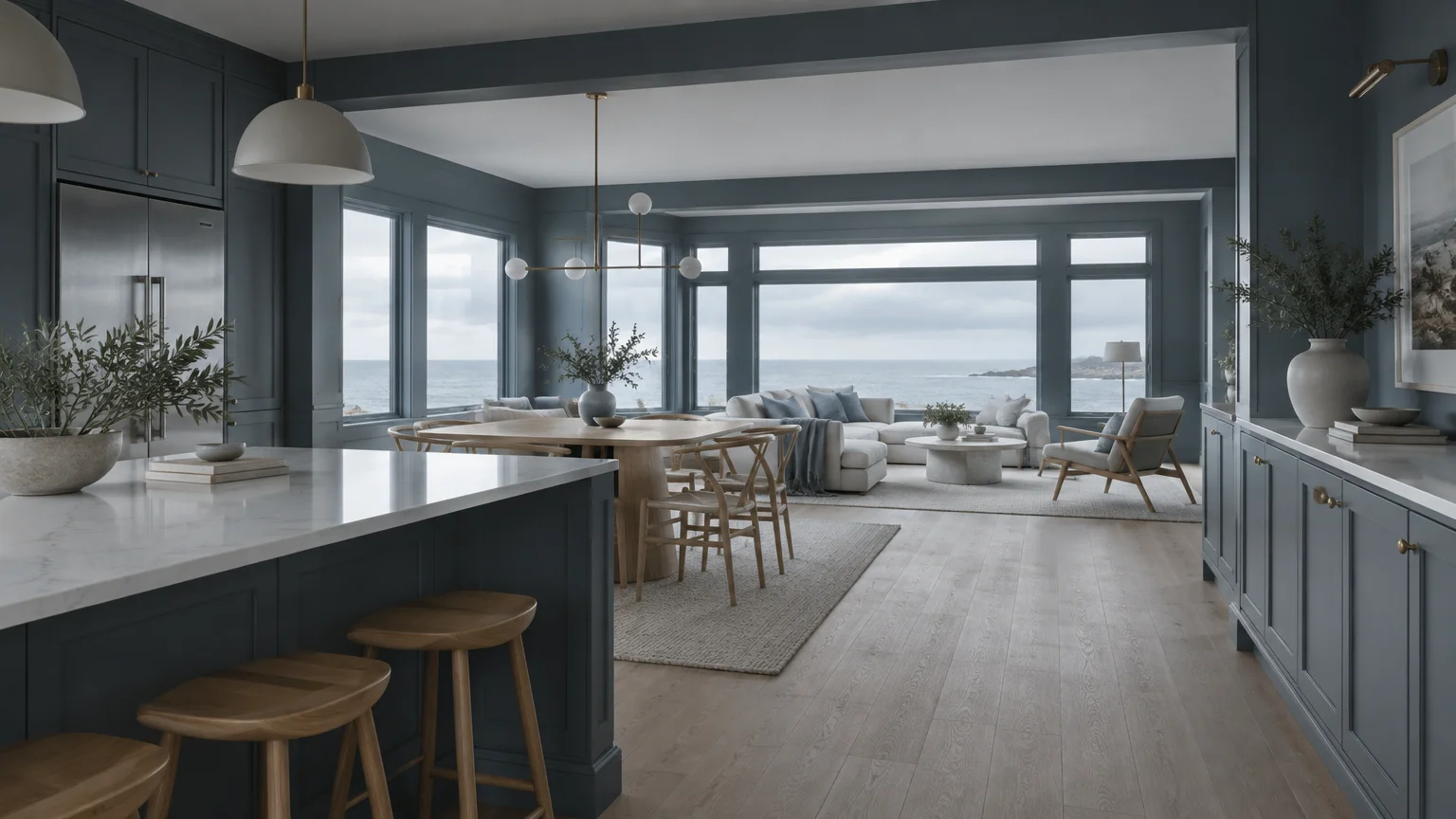 Open-concept kitchen and living room with slate blue cabinetry and trim framing expansive ocean views.