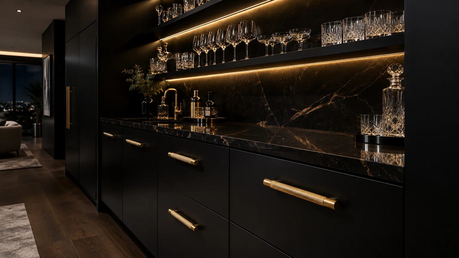 Matte black bar cabinets with textured gold handles, black marble countertop, and illuminated shelves holding glassware.
