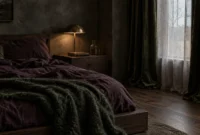 Moody bedroom with a dark wooden bed, deep purple bedding, green textured throw, bronze lamp, and velvet curtains.